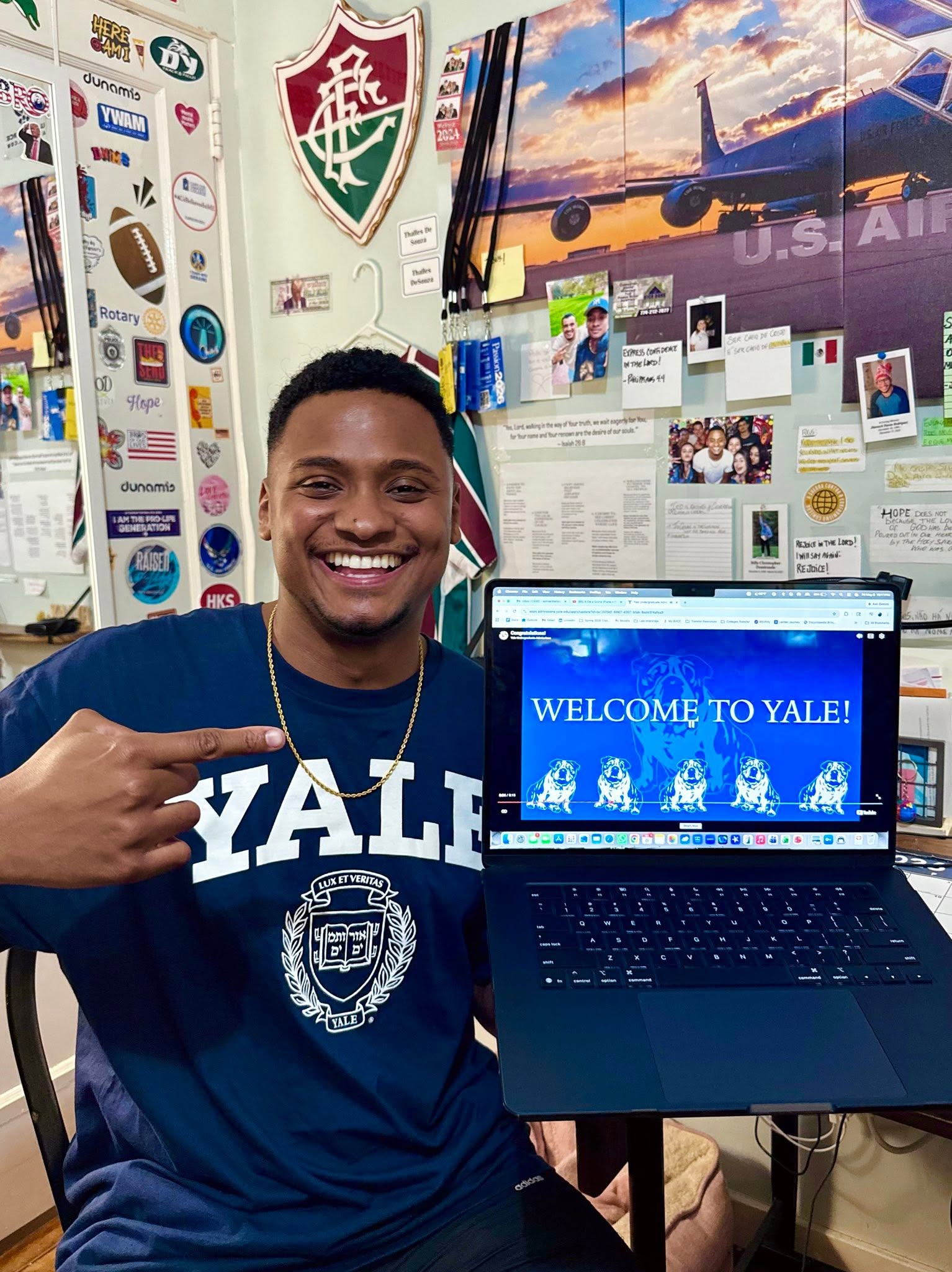 Thalles Winner DeSouza in a Yale T-shirt pointing at a laptop showing his acceptance page